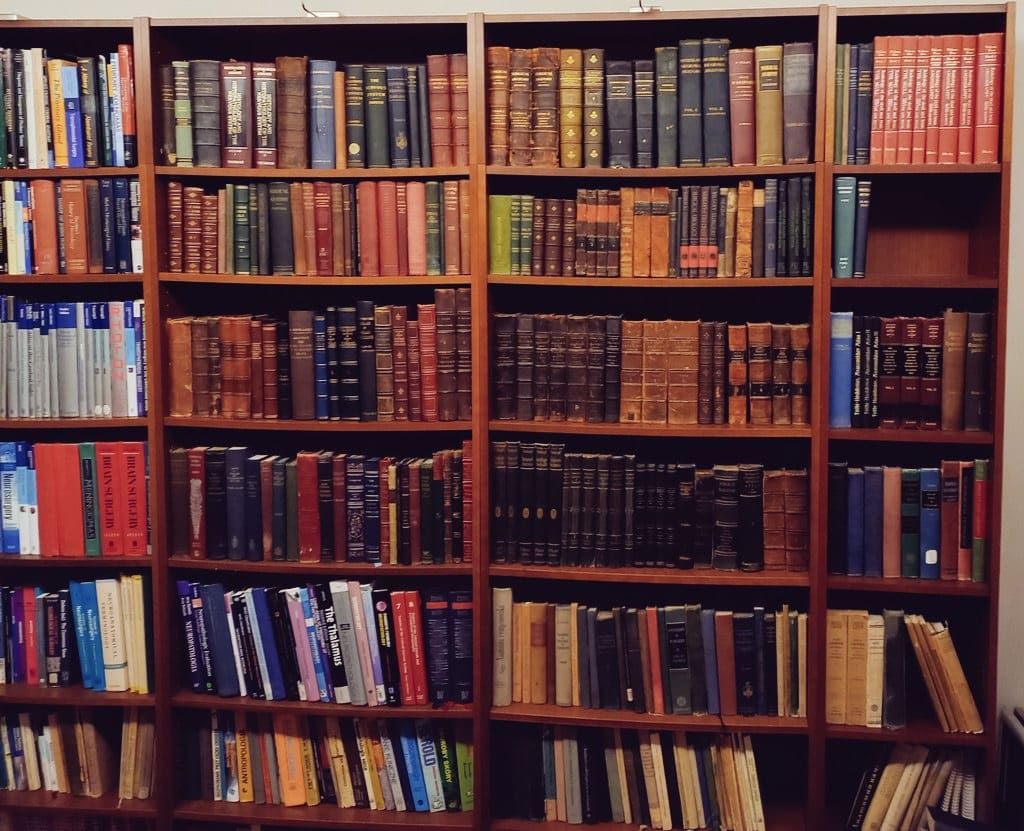 A bookshelf filled with lots of books and magazines.