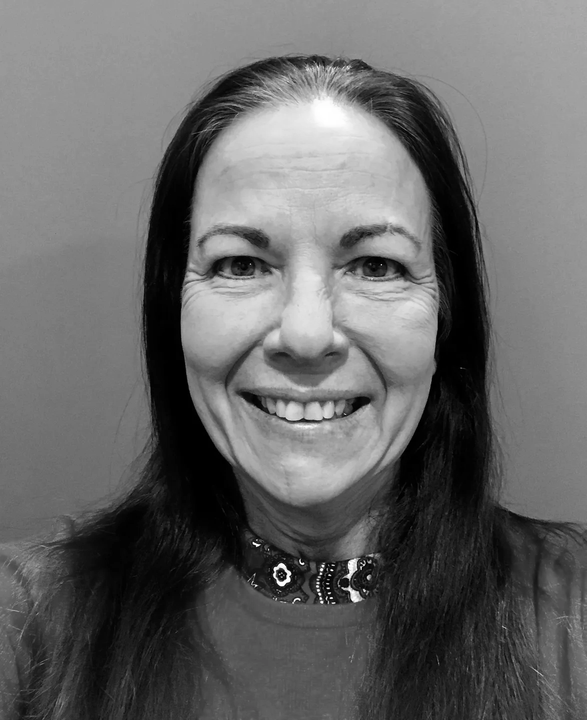 A black and white photo of a woman smiling.